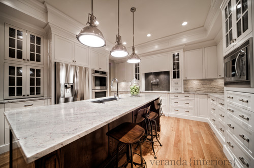 River White Granite Countertop an Overhang Island Top , White Cabinets, Glass Door White Cabinets, Graphite Glass Mosaic Tiles , Natural Stone Backsplash, White Oak Flooring, Stainless Steel Appliance and Stainless Steel Pendant Lighting